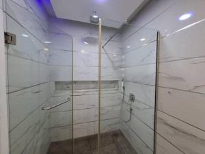 a bathroom with a shower with a glass door at Presken Apartment Ikoyi in Lagos
