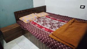 a bed with a quilt on top of it at Radha Rani Guest House in Sīkar +3 photos