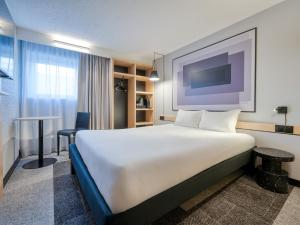 a hotel room with a large bed and a tv at Ibis Orly Chevilly Tram 7 in Chevilly-Larue +67 photos