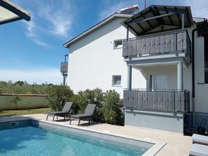 a house with a swimming pool and two chairs at Apolo Apartments - Pool & Garden Retreat in Pula