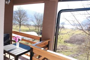 a table on a porch with a view of a field at Apartments Kenan in Plav