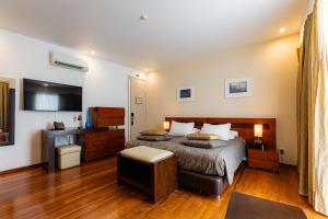 a hotel room with a bed and a television at Quinta do Mar in Água de Pau +75 photos