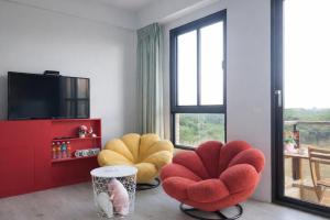 a living room with two chairs and a television at Blue Sea and Sunny B&B in Toucheng