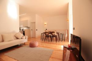 a living room with a couch and a table with chairs at Republica House in Trafaria