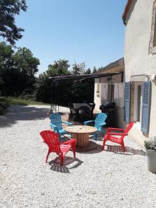 a patio with four chairs and a table and a grill at La Belle Noue in Bellenod-sur-Seine