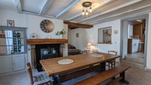 a dining room with a wooden table and a fireplace at La Belle Noue in Bellenod-sur-Seine