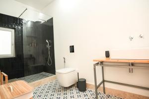 a bathroom with a shower and a toilet and a sink at Republica House in Trafaria +30 photos