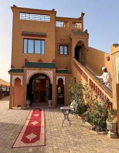 a man sitting on the stairs of a house at Riad Mifis in Rissani