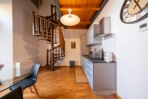 a kitchen with a table and a clock on the wall at Lungarno Buozzi 7 Apartments in Pisa