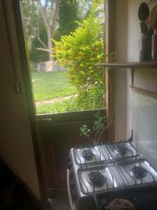 a stove in a kitchen with a view of a window at Chalé do Ben in São Thomé das Letras