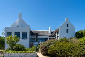 a white house on the beach with bushes at Manor at Longridge in Helderberg