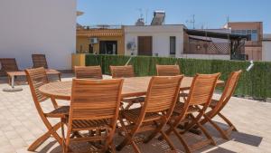a wooden table and chairs on a patio at Terrasini Downtown Little Square in Terrasini