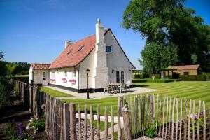 una casa bianca con una recinzione davanti di Cottage Nostalgia a Damme