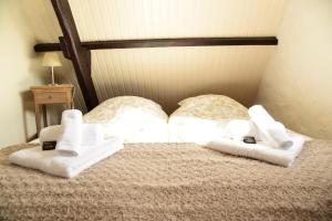 un letto con asciugamani bianchi sopra di Cottage Nostalgia a Damme