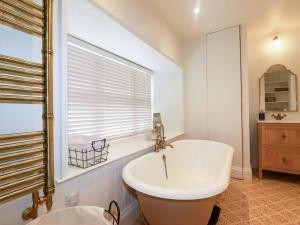 a bathroom with a tub and a sink and a window at Vosporth Villa in Newquay +36 photos