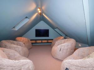 a attic living room with two chairs and a flat screen tv at Vosporth Villa in Newquay
