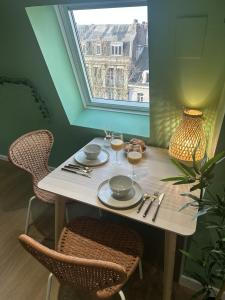 a table with two chairs and a table with wine glasses at Jungle Suite - Sauna et Relaxation in Arras
