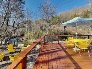 a deck with a table and chairs and an umbrella at Caney Creek in Jenkins Mill