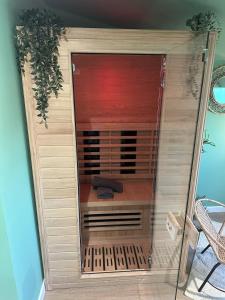 a closet with a glass door in a room at Jungle Suite - Sauna et Relaxation in Arras +10 photos