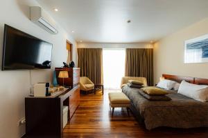 a hotel room with a bed and a television at Quinta do Mar in Água de Pau