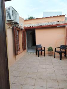 a patio with two chairs and a television on a building at La maison d'amour in Sanluri