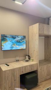 a room with a wooden desk with a tv on the wall at Agora ApartHotel in Tirana