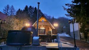 a log cabin with a trash can in front of it at Mókuslak Mátra in Mátraszentimre