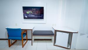 a room with a table and a chair and a desk at HOTEL ITACAIUNAS in Marabá
