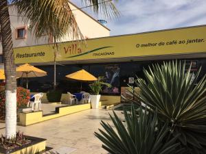 a restaurant with chairs and umbrellas in front of a building at HOTEL ITACAIUNAS in Marabá