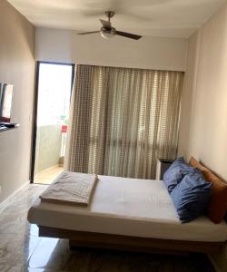 a bedroom with a bed with a ceiling fan and a window at Flat Próximo Shopping Santa Úrsula in Ribeirão Preto +6 photos