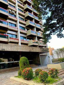 a large building with flowers in front of it at Flat Próximo Shopping Santa Úrsula in Ribeirão Preto