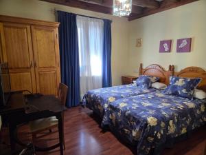 a bedroom with a bed and a desk and a window at Hotel Rural Las Farolas in San Rafael