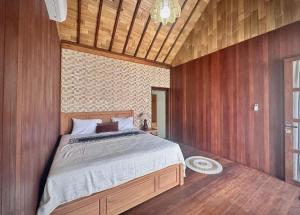 a bedroom with a large bed with wooden walls at Casa Loka in Canggu