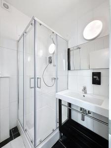 a white bathroom with a shower and a sink at Keyless Hotel - Van Gaver in Brussels