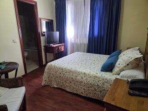 a hotel room with a bed and a table and a television at Hotel Rural Las Farolas in San Rafael