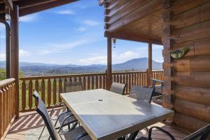 a table and chairs on the deck of a cabin at Smoky Mountain Bliss by Beyond Expectations in Sevierville