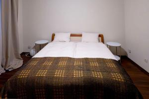 a bedroom with a large bed with two tables at GLEDKA Apartament in Veliko Tŭrnovo