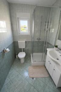 a bathroom with a shower and a toilet and a sink at Apartmani Čop Rab in Banjol +17 photos