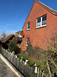 a fence in front of a brick house at Ferienwohnung Frieda in Bückeburg