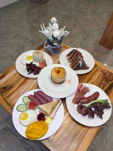 a table with plates of breakfast food on it at Natalie's Homestay Bed and Breakfast in El Nido