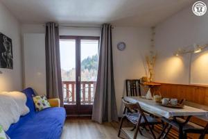 a bedroom with a bed and a table and a window at Dans les mélèzes in Saint-Pancrace