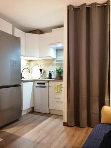a small kitchen with white cabinets and a sink at Dans les mélèzes in Saint-Pancrace +1 photo