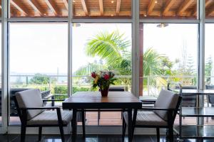 a table and chairs with a vase of flowers on it at Quinta do Mar in Água de Pau