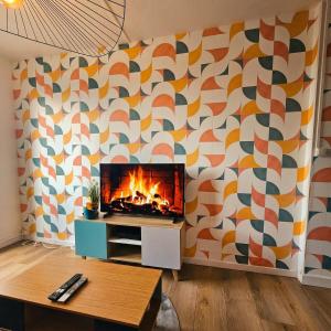a fireplace in a living room with a patterned wall at L'Atelier Eiffel Moderne & confortable in Saint-Brieuc