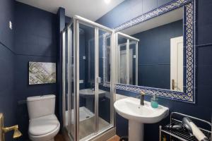 a blue bathroom with a toilet and a sink at Apartamentos Málaga centro in Málaga +22 photos