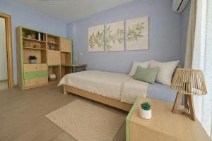 a small bedroom with a bed and a table at Alkion Villa Sea View, Olive Tree Garden & Spacious Terrace in Rhodes Town