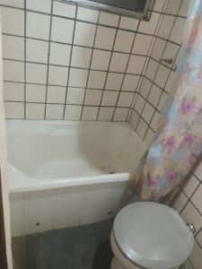 a bathroom with a toilet and a bath tub and a toilet at Chalé do Ben in São Thomé das Letras +8 photos