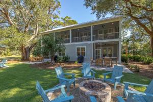a house with blue chairs and a fire pit at Seafarer Lodge South in Jekyll Island