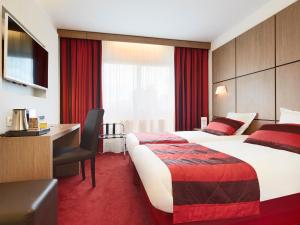 a hotel room with a large bed and a desk at Kyriad Grenoble Centre in Grenoble