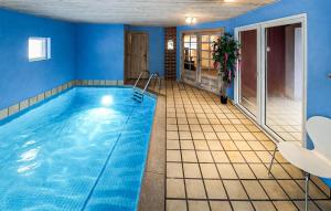 a swimming pool in a room with blue walls at Nice Home In Oksbøl With Sauna in Oksbøl